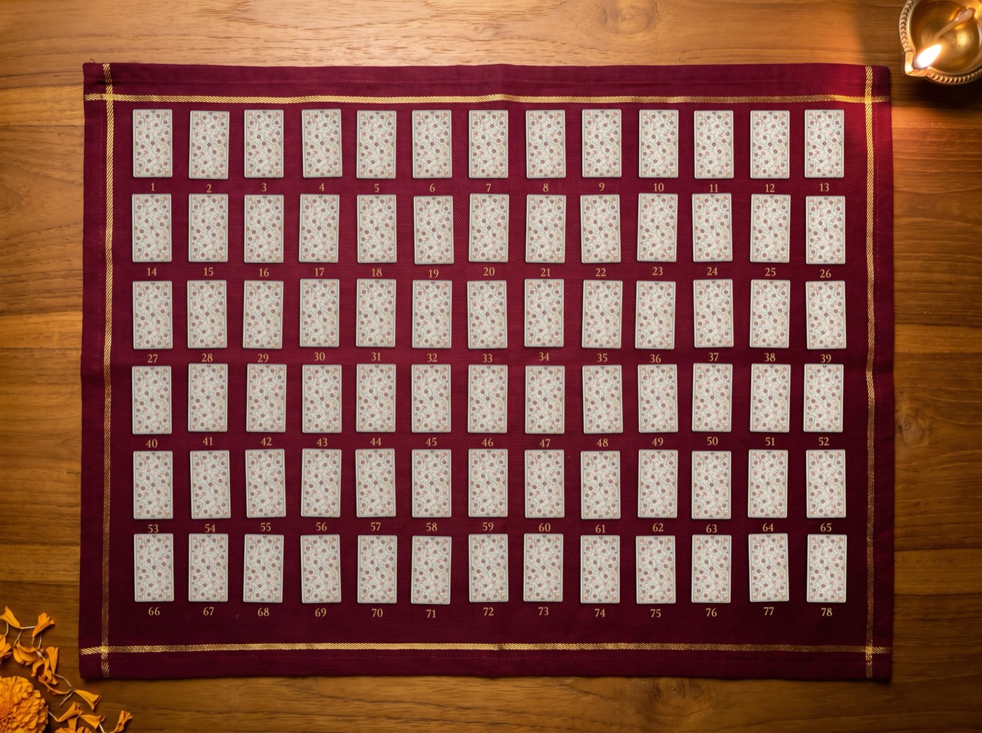 The full deck laid face down on a maroon cloth, numbered 1 to 78.